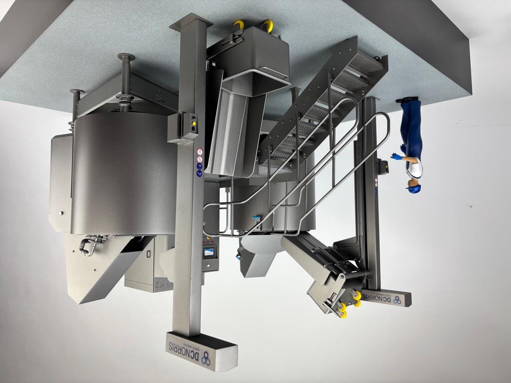 Twin kettle scale model at an angle, showing bin lift columns, access stair, tote bin and worker figure on gray base